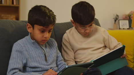 Zwei-Junge-Jungen-Sitzen-Zu-Hause-Auf-Dem-Sofa-Und-Spielen-Spiele-Oder-Streamen-Auf-Digitale-Tablets-8